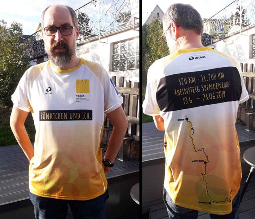 Vorn ist auf dem Shirt das Logo des Fördervereins zu sehen und ein schwarzes Textfeld mit einer gelben Schrift "Pünktchen und ich". Auf dem Rücken ist ein weiteres Textfeld mit "320km 11.700hm Rheinsteig Spendenlauf 19.6.-23.6.2019" zu sehen. Darunter eine schematische Darstellung des Rheinsteigverlaufs. Auf dem einen Ärmel befindet sich ein kreisrundes Logo des Fördervereins, auf dem anderen das Wanderzeichen des Rheinsteigs ein weißes "R" auf blauem Grund. An den Seiten steht jeweils hochkant vbbsk.de