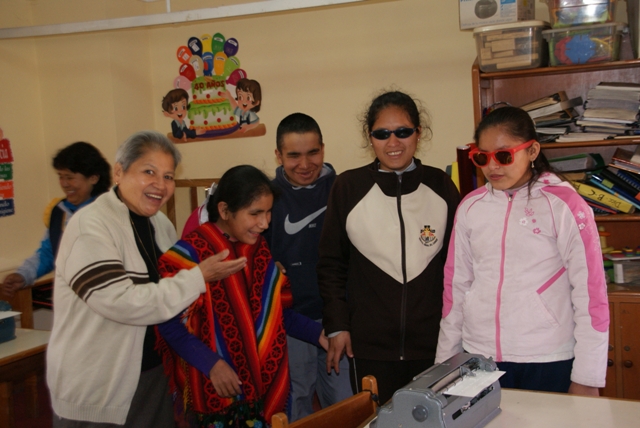 Blindenklasse in Cusco vor einer Brailleschreibmaschine.