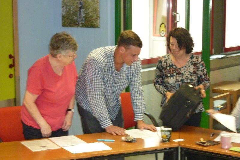 Ein Jugendlicher bekommt von der 1. Vorsitzenden seine Laptoptasche überreicht.